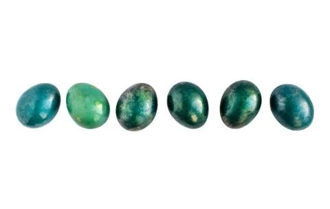 Easter eggs in different shades of turquoise and gold in a row on isolated white Stock Photos