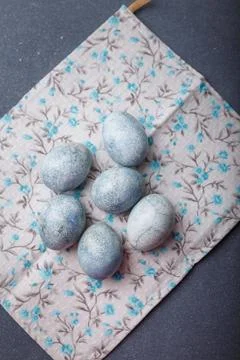 Easter eggs DIY painted blue on grey wooden background with kitchen towel Stock Photos