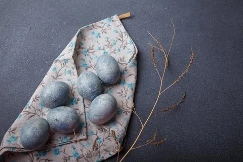 Easter eggs DIY painted blue on grey wooden background with kitchen towel Stock Photos