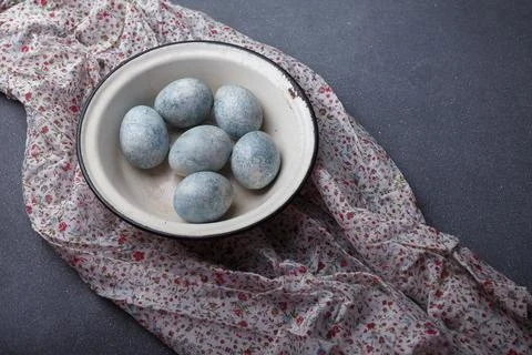 Easter eggs DIY painted blue in white bowl on grey wooden background Stock Photos