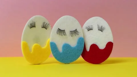 Easter eggs with eyelashes on a colored background Vidéo 143014348