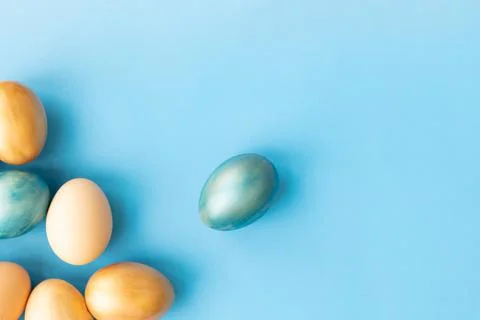 Easter eggs, flowers on blue background. Flat lay, top view, copy space. Easter Stock Photos