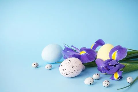 Easter eggs with flowers on a blue background, place for text. Stock Photos