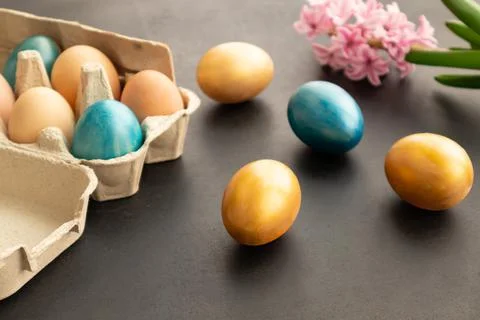 Easter eggs, flowers on dark background. Easter day. Stock Photos