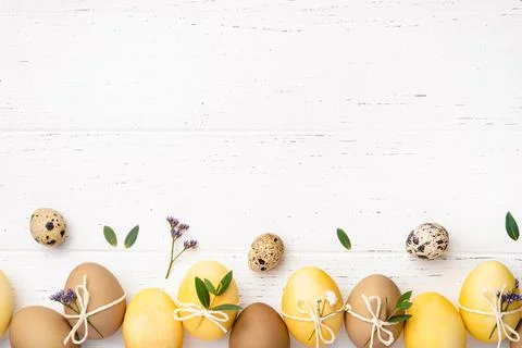 Easter eggs with flowers on a white table. Stock Photos