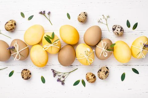 Easter eggs with flowers on a white table. Stock Photos