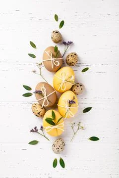 Easter eggs with flowers on a white table. Stock Photos