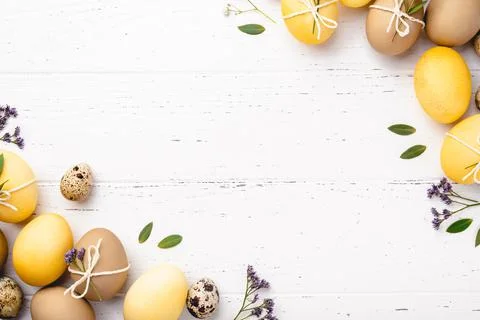 Easter eggs with flowers on a white table. Stock Photos