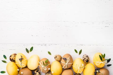 Easter eggs with flowers on a white table. Stock Photos