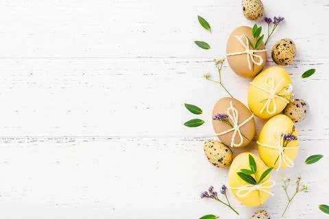 Easter eggs with flowers on a white table. Stock Photos