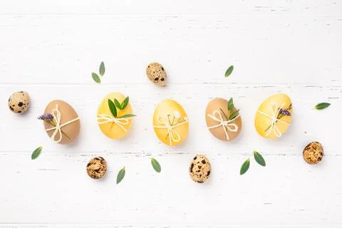 Easter eggs with flowers on a white table. Stock Photos