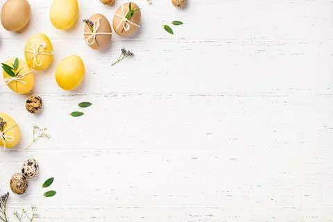 Easter eggs with flowers on a white table. Stock Photos