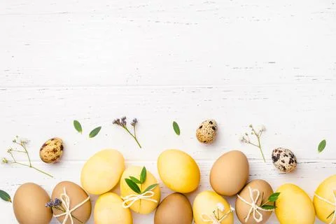 Easter eggs with flowers on a white table. Stock Photos