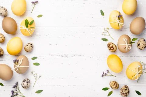 Easter eggs with flowers on a white table. Stock Photos