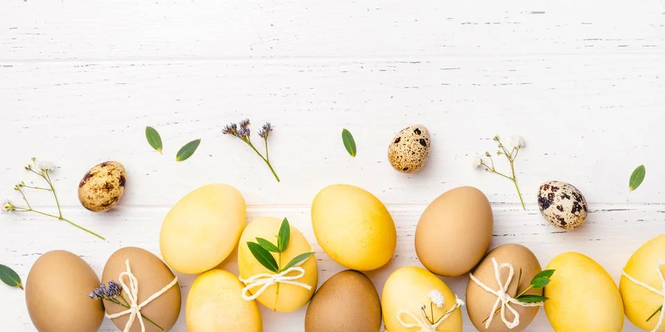Easter eggs with flowers on a white table. Stock Photos