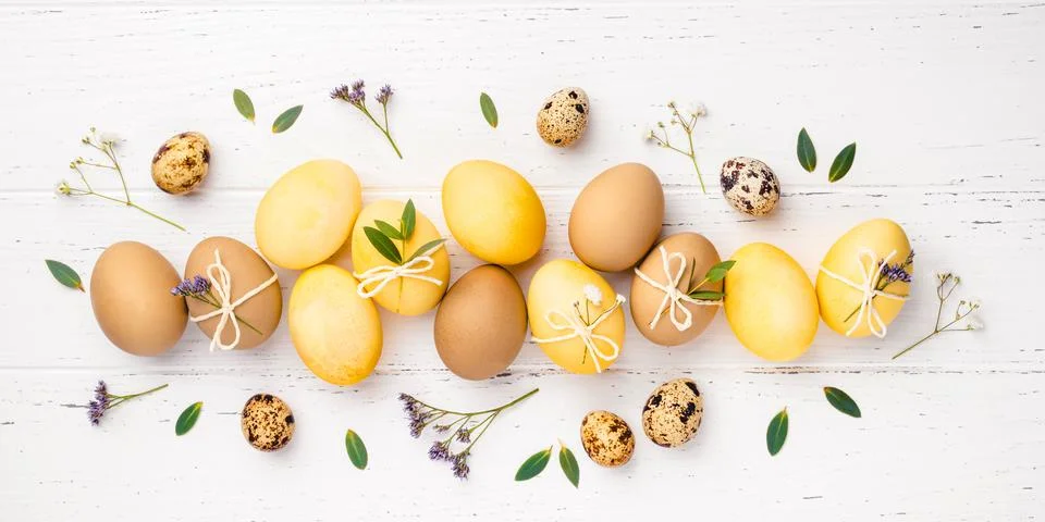 Easter eggs with flowers on a white table. Stock Photos