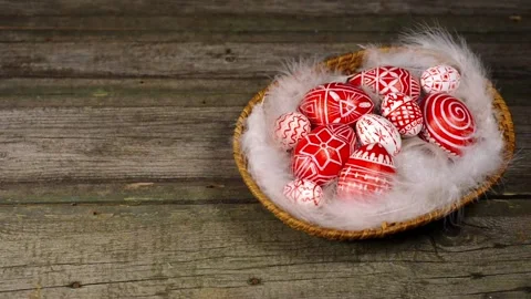 Easter eggs with folk white pattern inside basket on wood. Man add egg Stock Footage 127886632