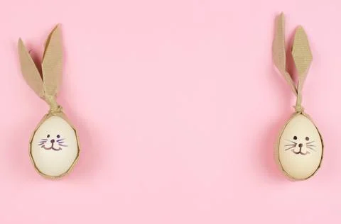 Easter eggs in the form of a rabbit on a pink background with place for text. Stock Photos