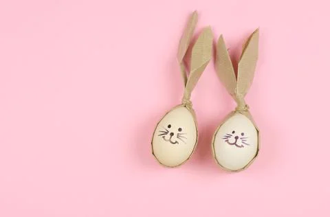 Easter eggs in the form of a rabbit on a pink background with place for text. Stock Photos