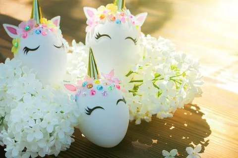 Easter eggs in the form of a unicorn with white delicate flowers. The minimum Photos