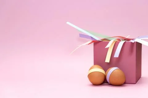 Easter eggs in front of pink square box on empty background Foto stock