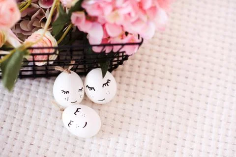 Easter eggs with funny faces  with flowers closeup. Spring time. Top view. Stock Photos