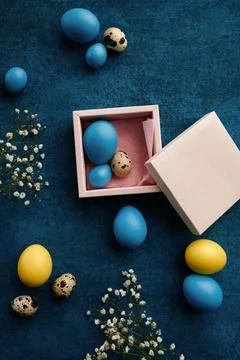 Easter eggs in gift box on blue cloth background Stock Photos