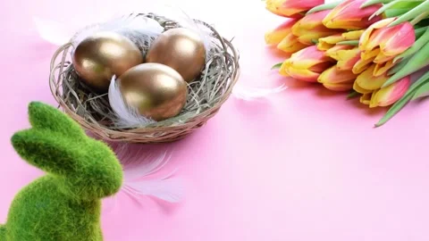 Easter eggs gold. Golden colour egg in basket with spring tulips, white feathers Stock Footage 149705208