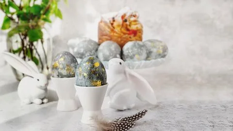 Easter eggs with gold pattern. A plate with Easter eggs and bunny figures. Th 库存照片
