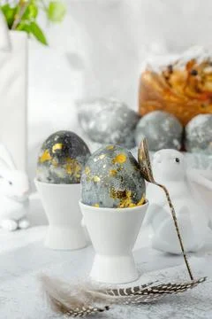 Easter eggs with gold pattern. A plate with Easter eggs and bunny figures. Th Stock Photos