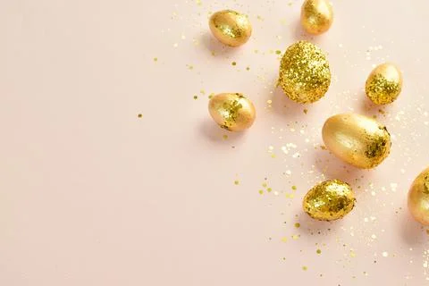 Easter eggs with gold sequins on a beige background. Banner for a happy Easte Foto stock