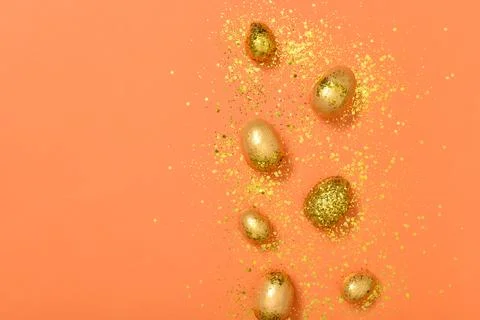 Easter eggs with gold sequins on an orange background. Foto stock