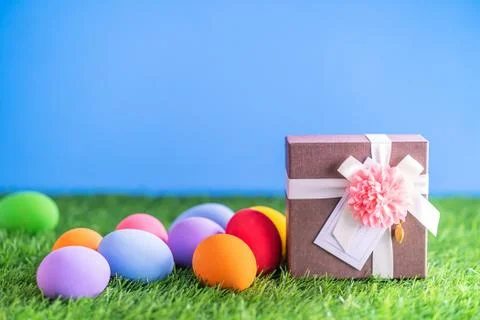 Easter eggs on grass and gift box Stock Photos