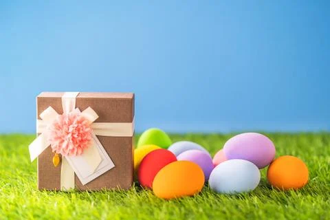 Easter eggs on grass and gift box Stock Photos