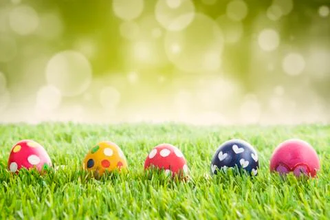 Easter eggs on grass with bokeh background Illustrazione stock
