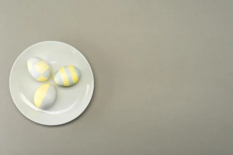 Easter eggs in a gray plate on a gray background with place for text. View fr Stock Photos