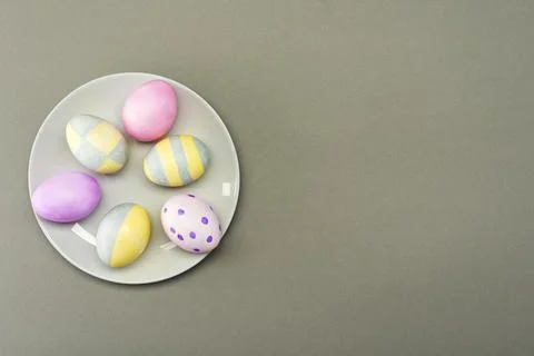 Easter eggs in a gray plate on a gray background with place for text. View fr Stock Photos