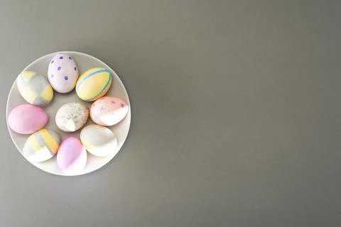 Easter eggs on a gray plate on a gray background with place for text. View fr Stock Photos