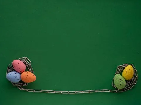 Easter eggs on green background with metal chain Stock Photos