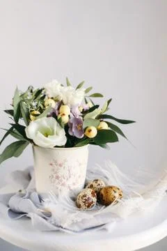 Easter eggs with green branches and yellow berries on white and gray backgrou Foto stock