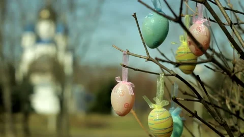 Easter eggs hang on tree branches against the backdrop of the church. Stock Footage 181024197