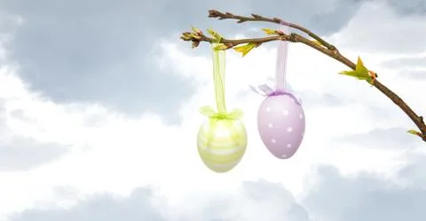Easter eggs hanging on branch in front of bright sky Stock-Illustration