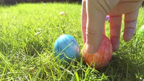 Easter eggs hidden in green grass ready for Easter egg hunt game children hands Stock Footage 234521757