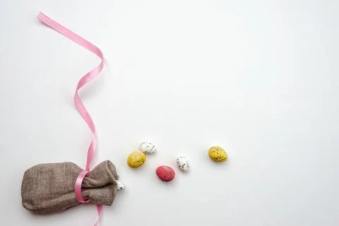 Easter eggs in jute bag on white background. Copy space. Stock Photos