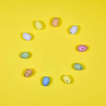 Easter eggs laid out in a circle on a yellow background. View from above. The Stock Photos
