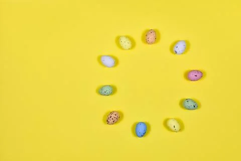 Easter eggs laid out in a circle on a yellow background. View from above. The Stock Photos