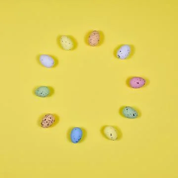 Easter eggs laid out in a circle on a yellow background. View from above. Stock Photos