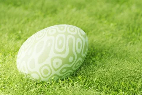 Easter eggs on the lawn in the grass. Green Easter egg with patterns in gre.. Ilustración de archivo