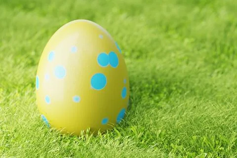 Easter eggs on the lawn in the grass. Yellow Easter egg with blue patterns .. Ilustración de archivo