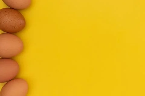 Easter eggs laying on the side on the yellow background 库存照片